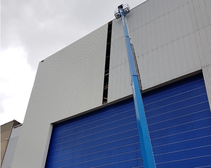 Nacelle devant un hall industriel pendant un désamiantage
