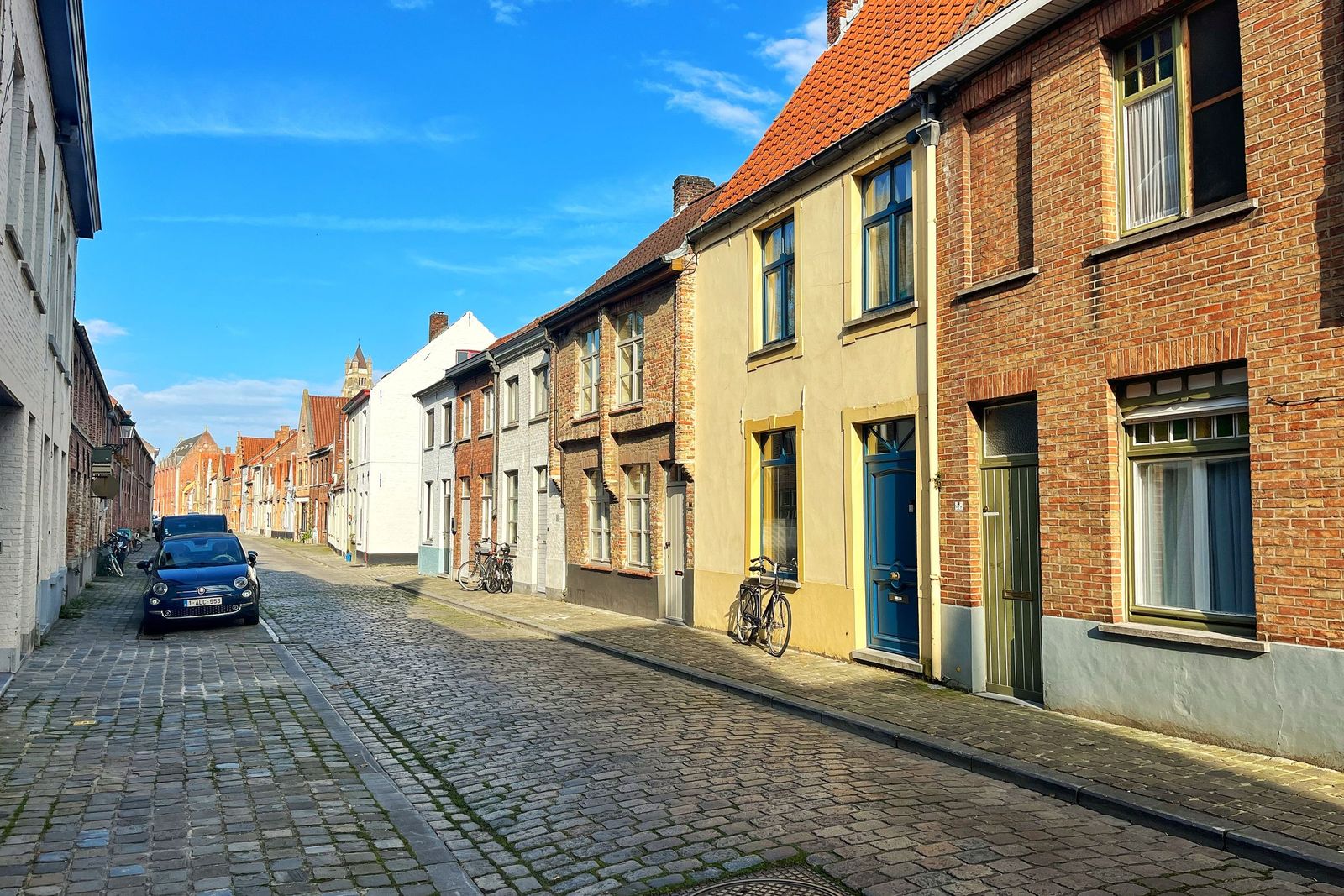 Cobbled street with brick houses and a bicycle against a facade in Bruges