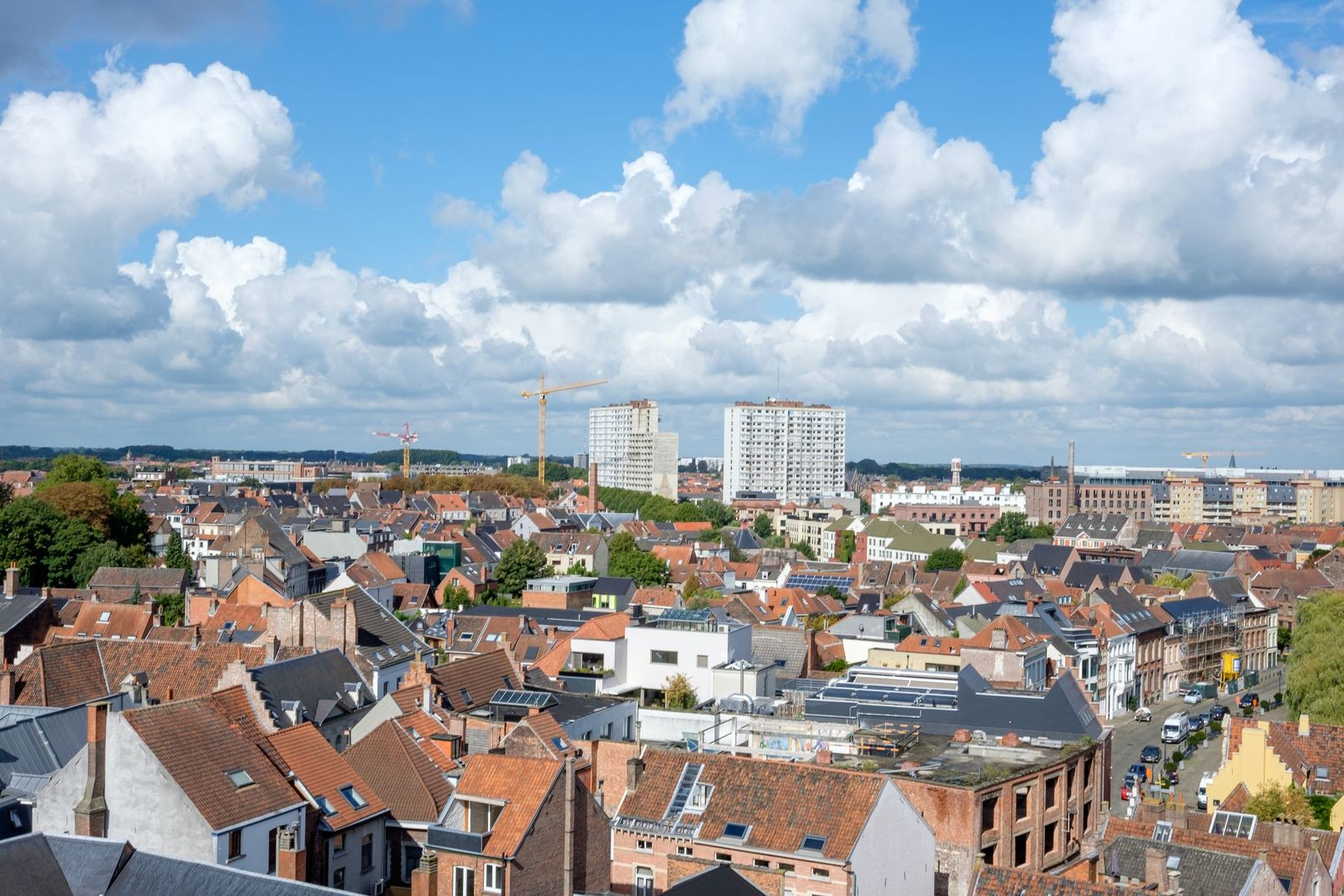 View over the rooftops of Ghent, with terraced houses and taller buildings in the distance