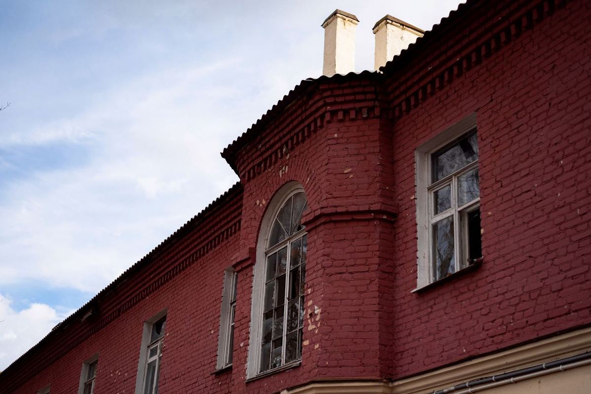 Red brick facade with an arched window
