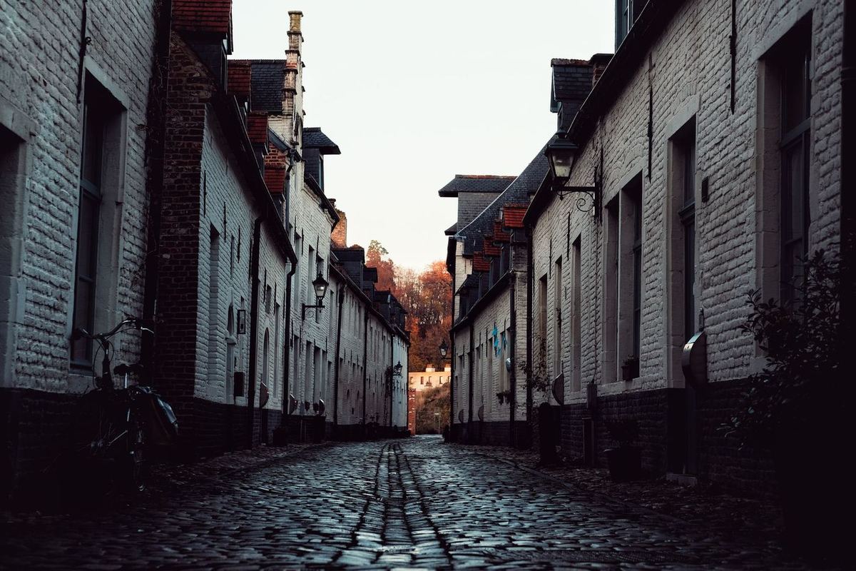 Kasseistraatje met witgekalkte bakstenen huizen in Leuven