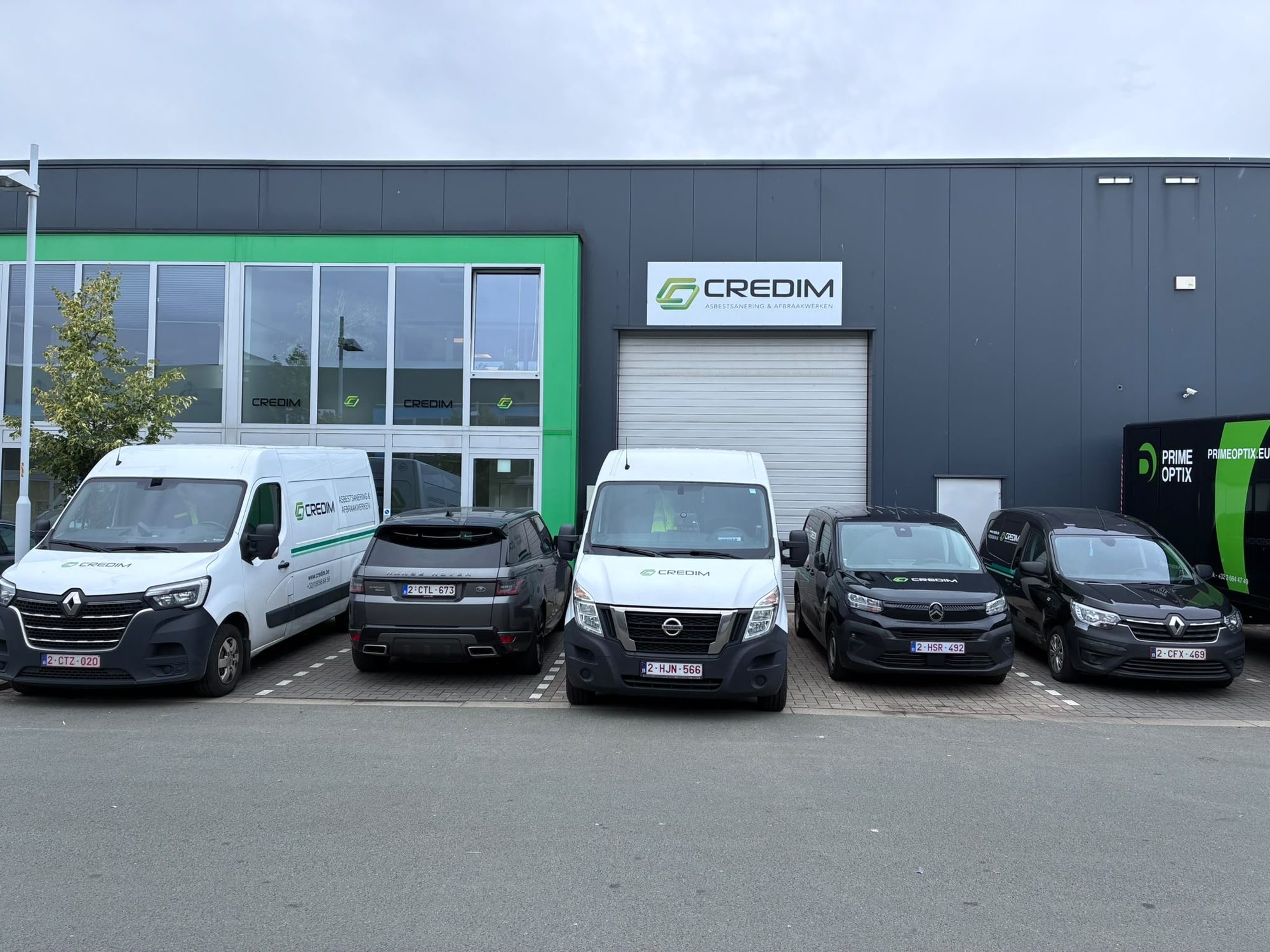Credim vans in front of the company building bearing the Credim logo