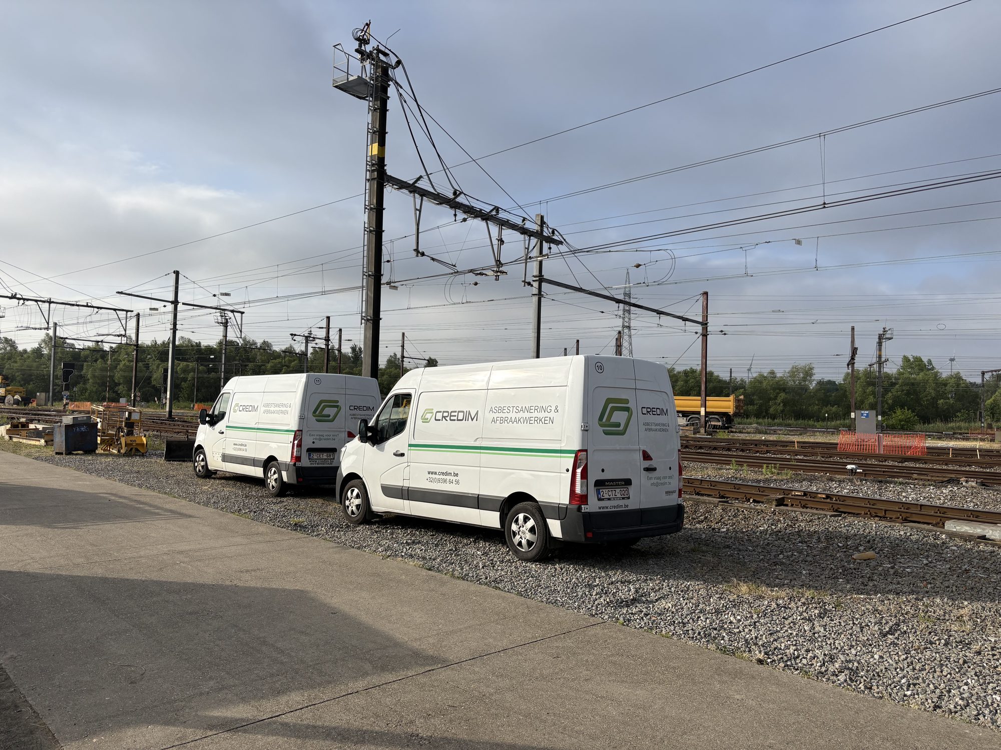 Two Credim vans next to a railway line