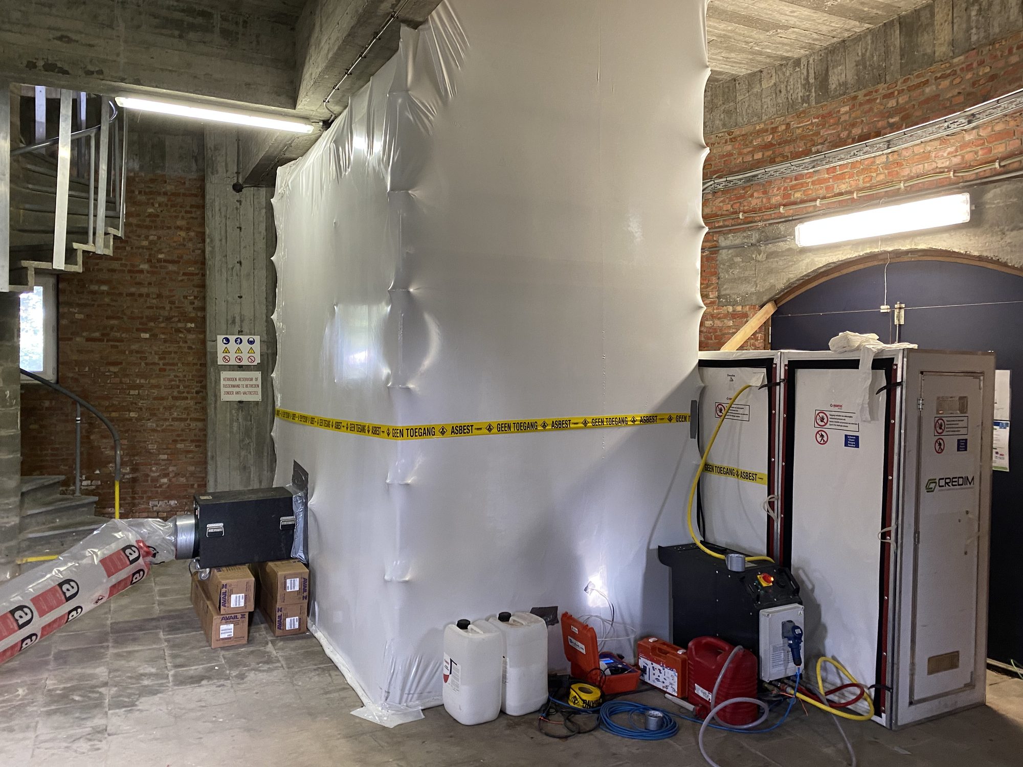 Zone hermétique fermée avec ruban de balisage dans un château d'eau, pour le retrait d'isolation de conduites
