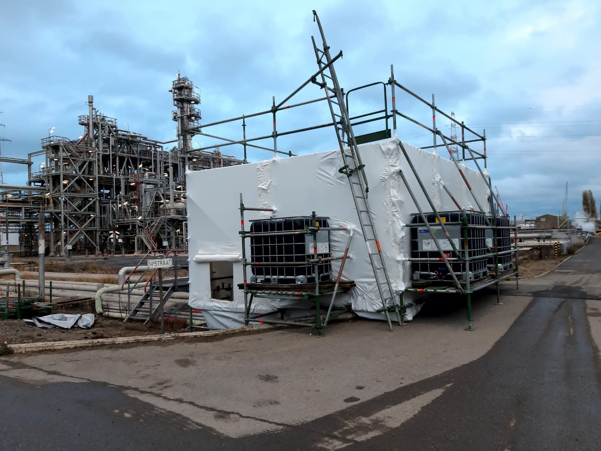 Hermetic zone with scaffolding on an industrial site, with industrial installations in the background