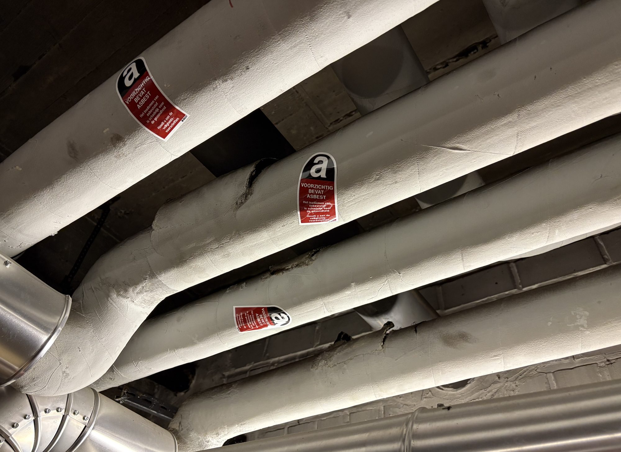 Insulated pipes with asbestos warning stickers