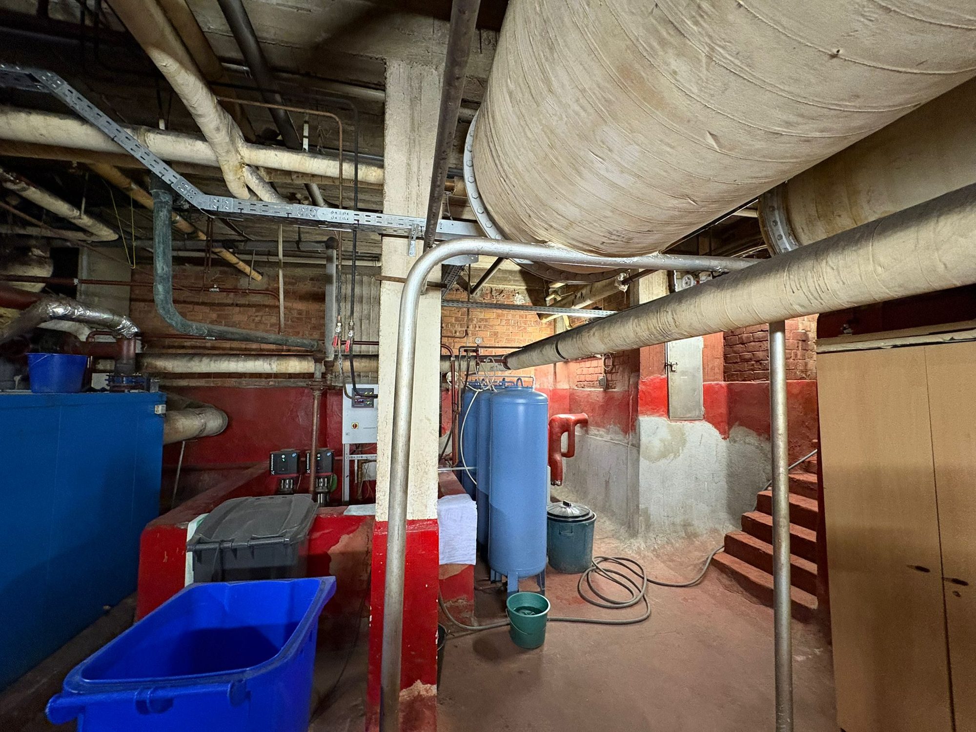 Plant room with many insulated pipes below the ceiling