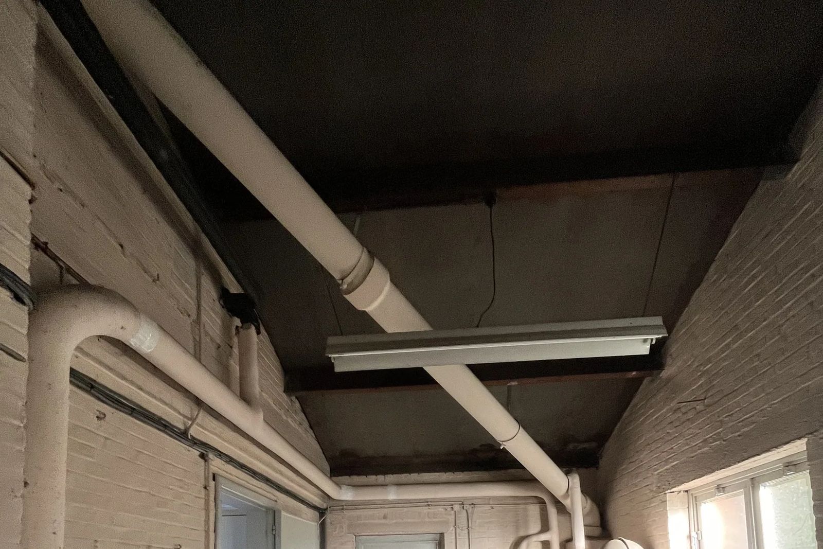 Corridor ceiling with an insulated pipe and a fluorescent light