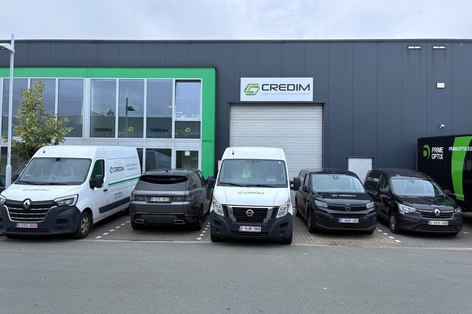 Bâtiment de Credim avec des véhicules garés devant, dont des camionnettes au logo Credim