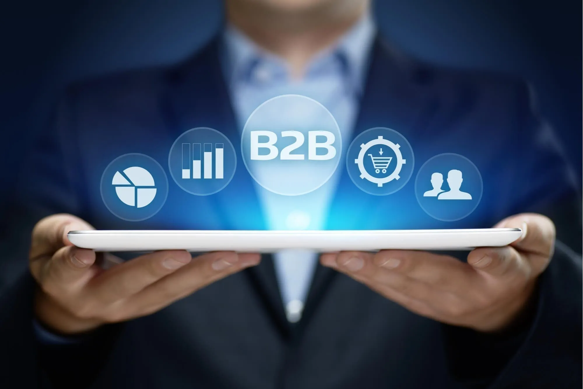 Zakenman houdt tablet vast met digitale B2B-marketingiconen erboven