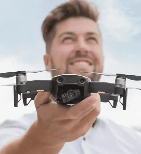 Lachende man houdt een compacte drone vast in zijn hand