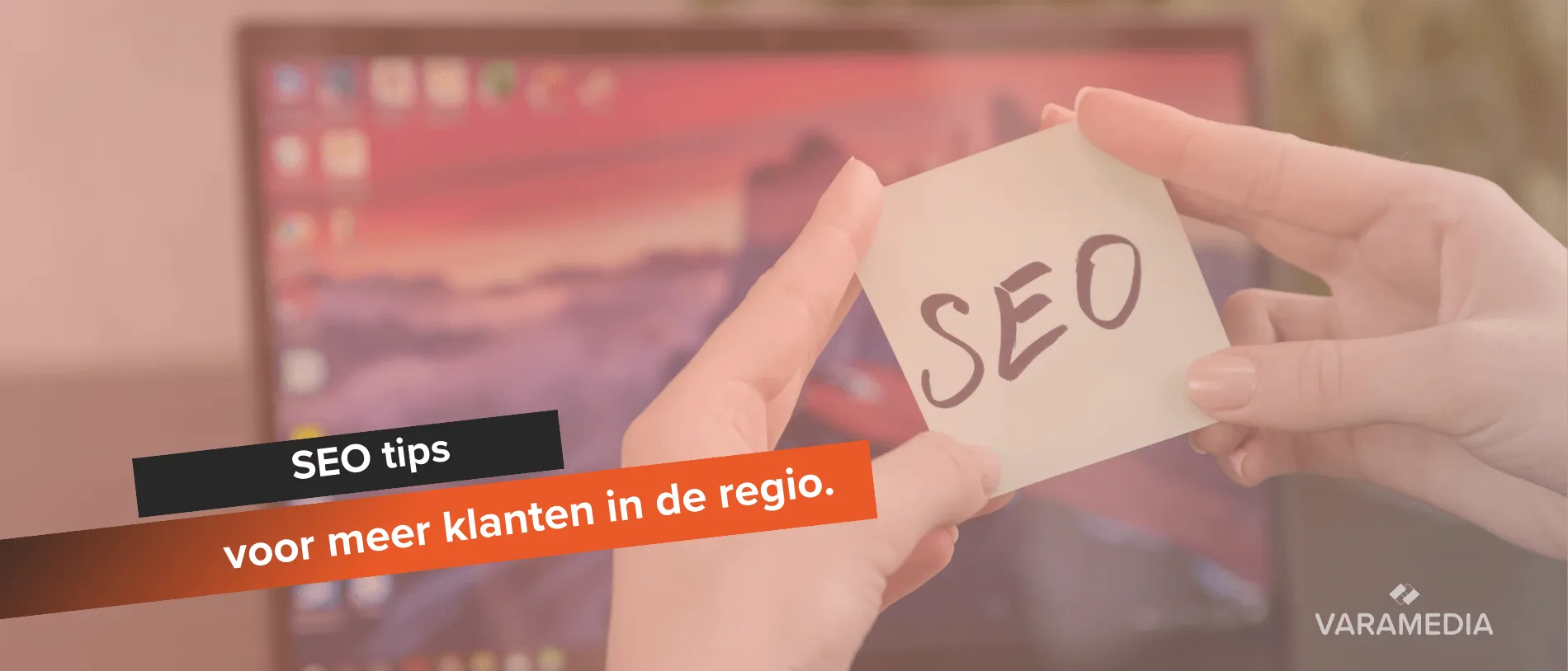 Handen houden papier met SEO vast voor computerscherm