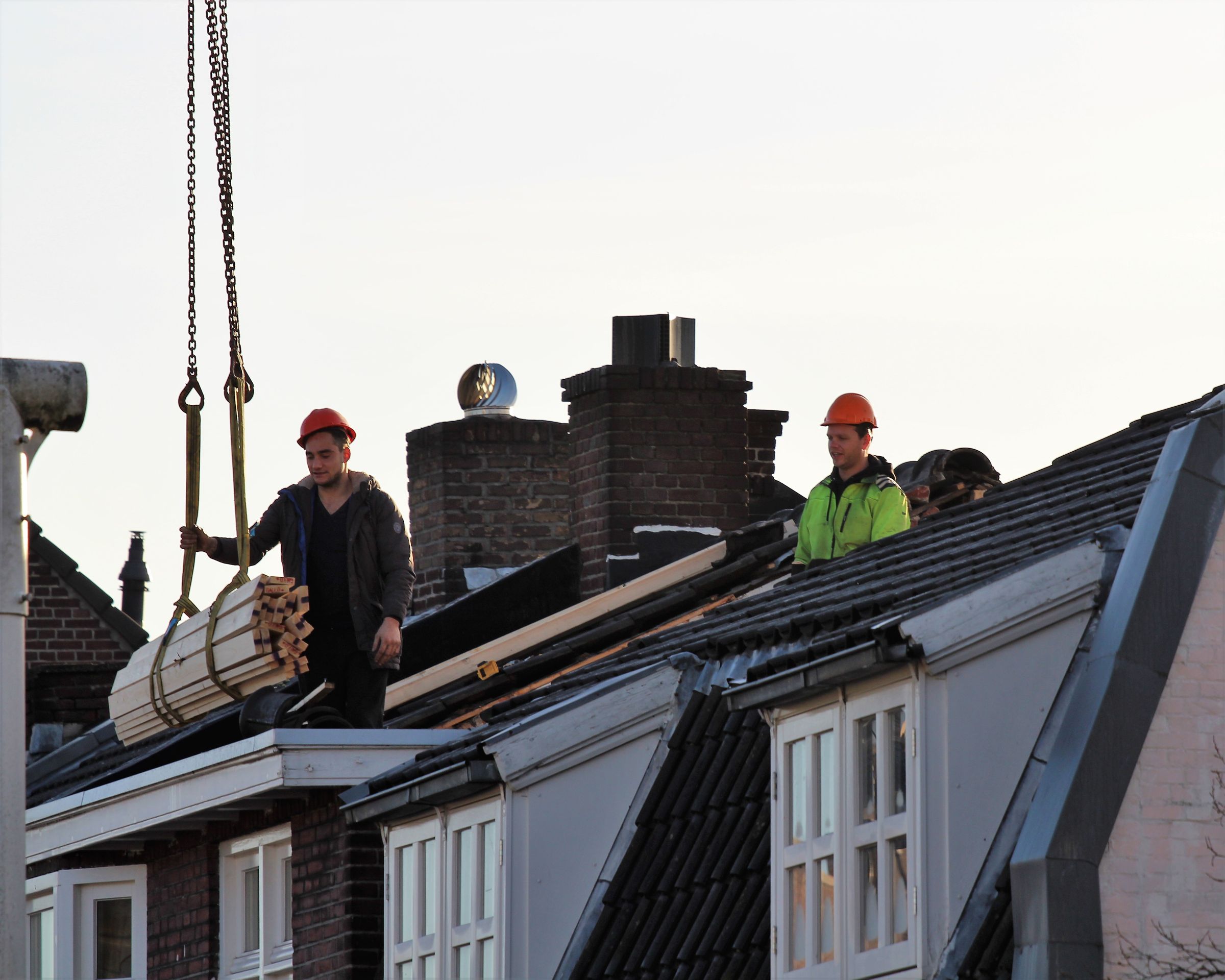 Dakwerkers aan het werk op het dak van een woning